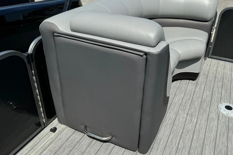 Slide: The Image of 2020 Manitou Oasis SR boat interior with gray seating and storage compartment. - 9