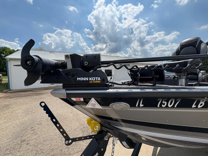 Slide: The Image of Lund 1975 Pro-V boat with Minn Kota Ulterra motor, parked outdoors under a cloudy sky. - 18