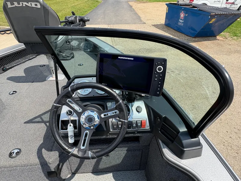 Slide: The Image of 2021 Lund 1975 Pro-V boat dashboard with steering wheel and navigation system. - 19