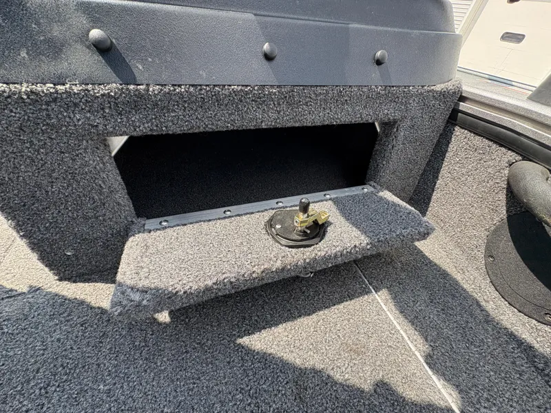 Slide: The Image of Interior of 2021 Lund 1975 Pro-V boat showing storage compartment and carpeted flooring. - 28