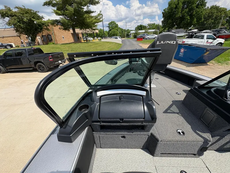 Slide: The Image of 2021 Lund 1975 Pro-V boat interior with open windshield, parked outdoors. - 33