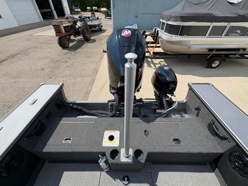 Slide: The Image of 2021 Lund 1975 Pro-V boat with motor, docked near other boats and equipment. - 41