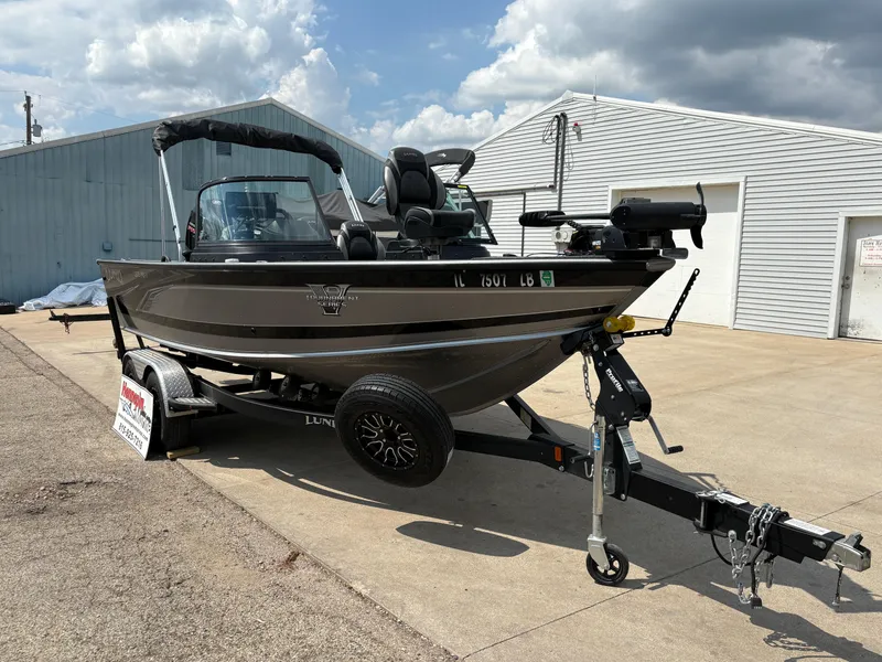 Slide: The Image of 2021 Lund 1975 Pro-V boat on trailer, parked outdoors under cloudy sky. - 5