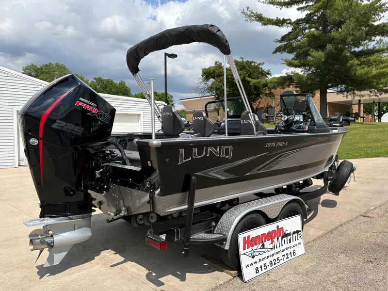 Slide: The Image of 2021 Lund 1975 Pro-V boat on trailer, displayed outdoors at Hennepin Marine dealership. - 6