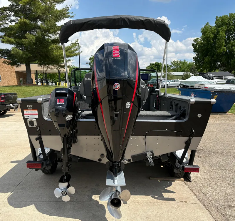 Slide: The Image of 2021 Lund 1975 Pro-V boat with dual outboard motors, parked outdoors. - 8
