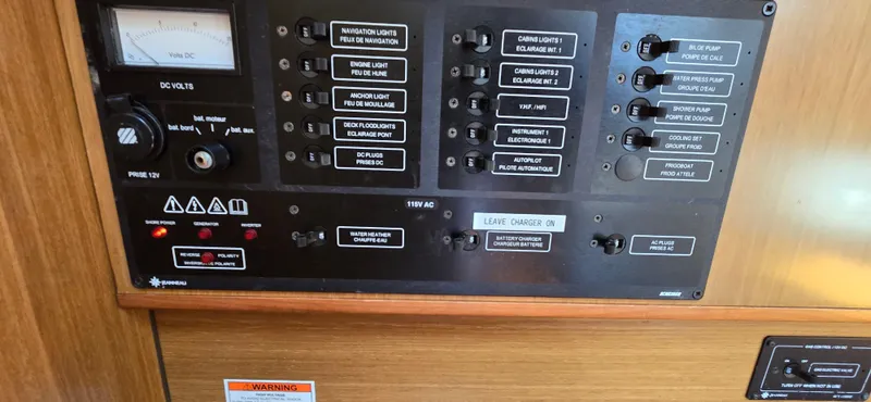Slide: The Image of Control panel of a 2006 Jeanneau Sun Odyssey 40.3 sailboat, featuring various switches and indicators. - 13