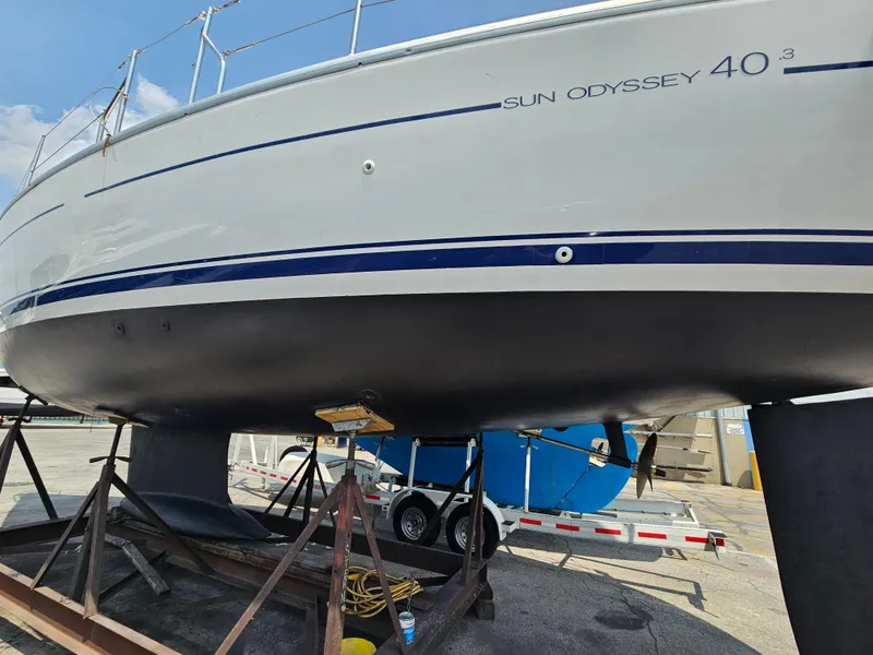 Slide: The Image of 2006 Jeanneau Sun Odyssey 40.3 sailboat on dry dock, showcasing hull and keel. - 2