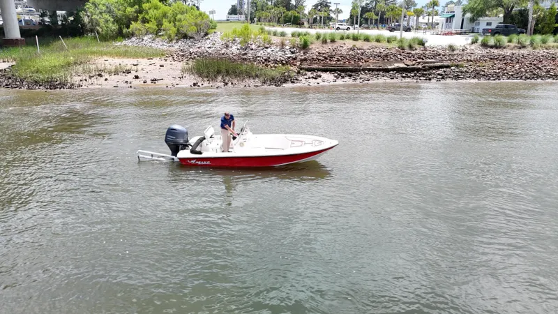 Slide: The Image of A 2006 Mako 1801 Inshore boat on calm water near a rocky shoreline. - 19