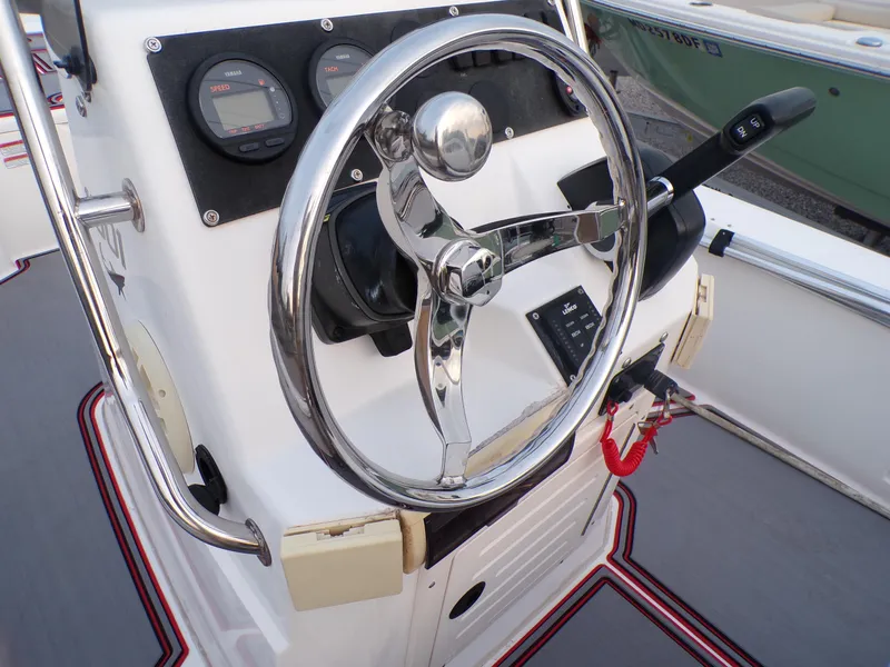 Slide: The Image of Steering console of a 2006 Mako 1801 Inshore boat with chrome wheel and gauges. - 9
