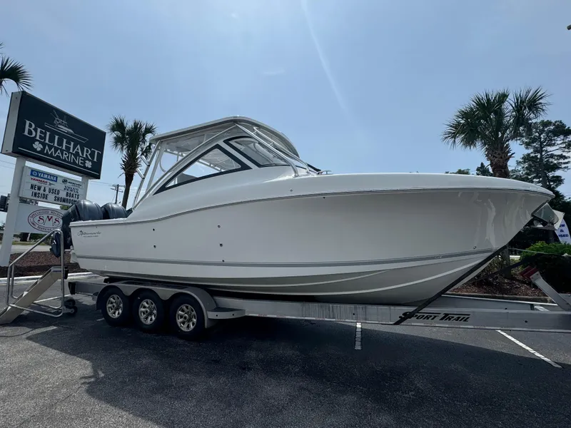 The Image of 2025 Albemarle 31 Dual Console boat cruising on a sunny day near coastal homes. - 0