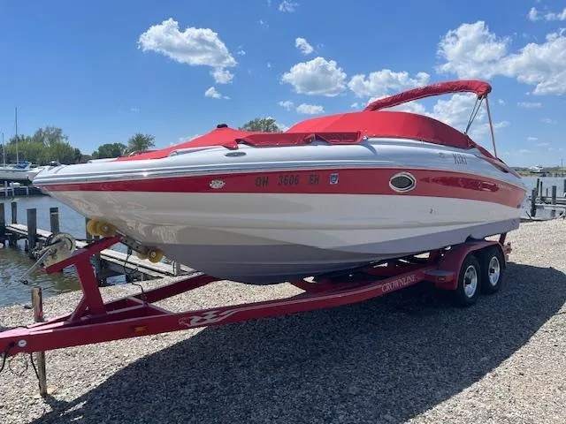 Slide: The Image of 2007 Crownline 240 EX boat on red trailer, parked near a dock under a blue sky. - 2