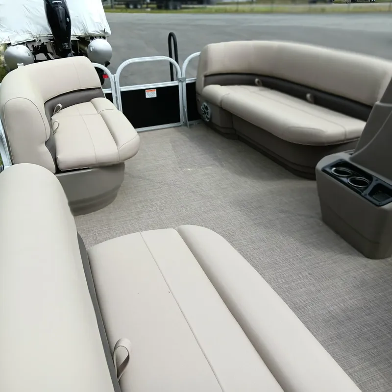 Slide: The Image of 2025 Sun Tracker Party Barge 16 DLX interior with beige seating and cup holders. - 6