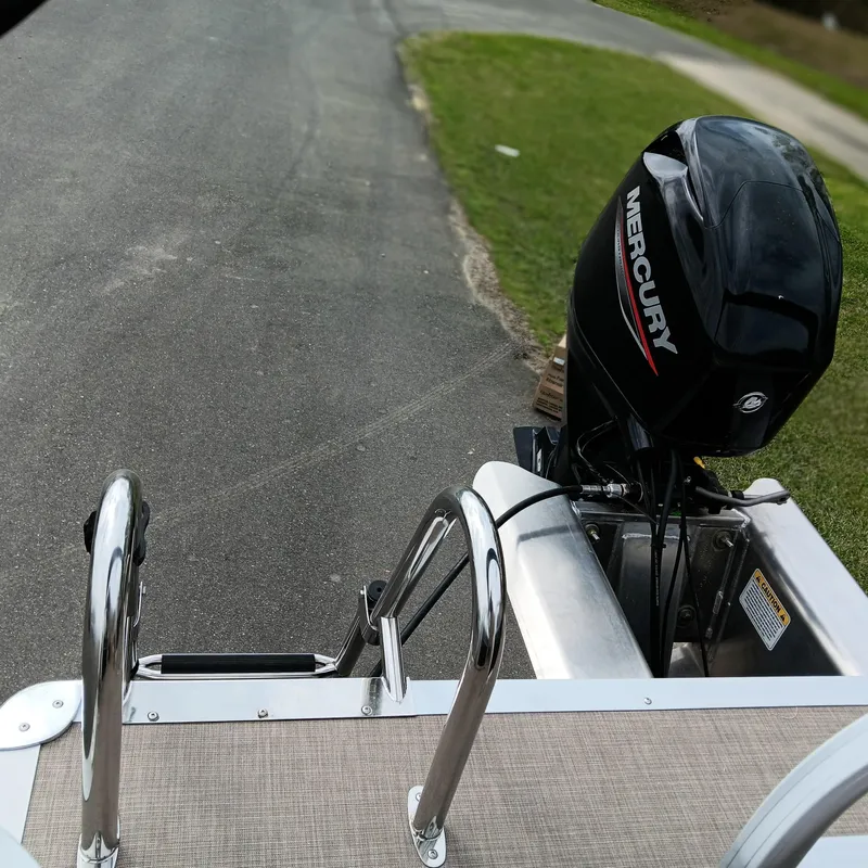 Slide: The Image of 2025 Sun Tracker Party Barge 16 DLX with Mercury outboard motor on a road. - 9