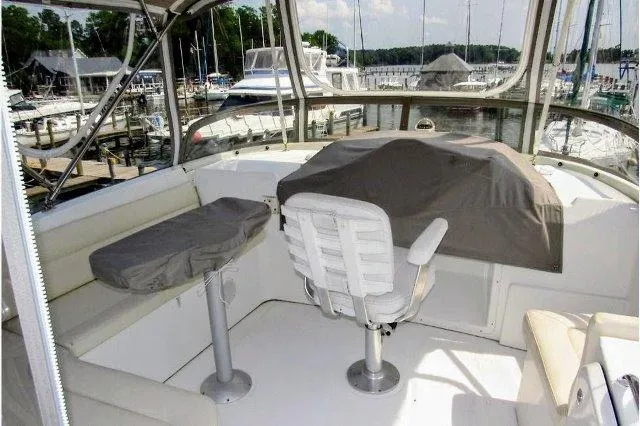 Slide: The Image of 2006 Beneteau Swift Trawler 42 flybridge with seating, helm chair, and marina view. - 14