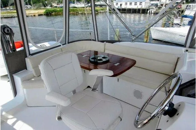 Slide: The Image of 2006 Beneteau Swift Trawler 42 cockpit with seating, table, and steering wheel. - 15