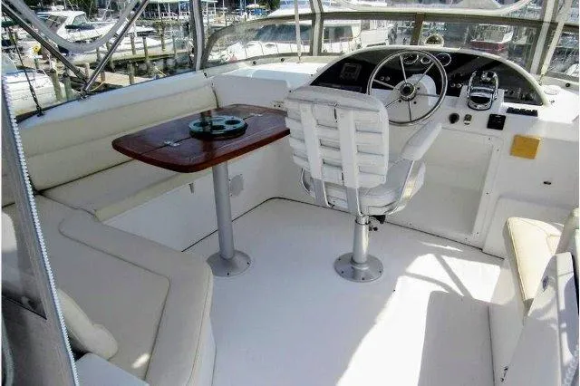 Slide: The Image of 2006 Beneteau Swift Trawler 42 helm with seating and wooden table. - 17