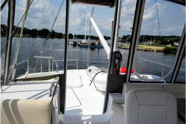 Slide: The Image of 2006 Beneteau Swift Trawler 42 on calm water, featuring spacious deck and scenic view. - 18