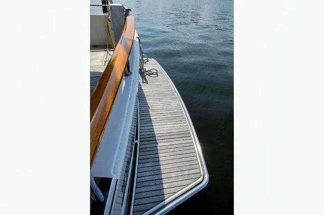 Slide: The Image of 2006 Beneteau Swift Trawler 42, wooden deck detail, docked on calm water. - 22