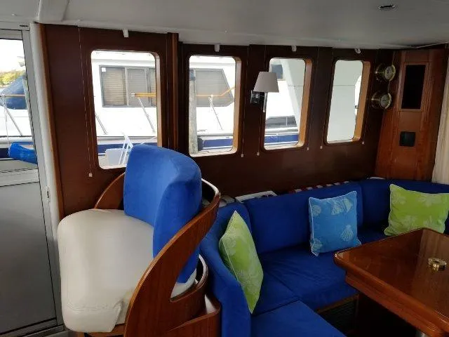 Slide: The Image of Interior of 2006 Beneteau Swift Trawler 42 with blue seating and wooden accents. - 27