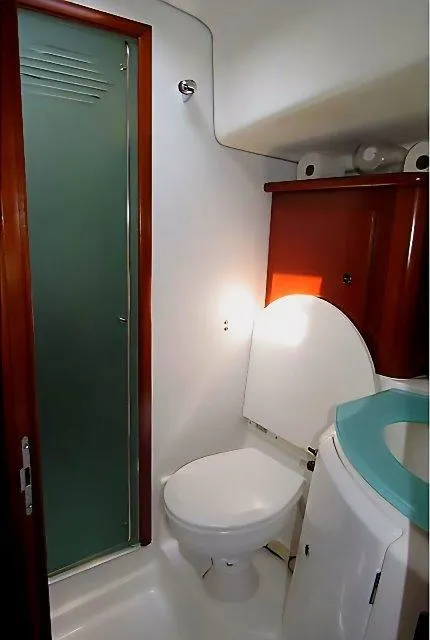 Slide: The Image of 2006 Beneteau Swift Trawler 42 bathroom with shower, toilet, and wooden cabinetry. - 42