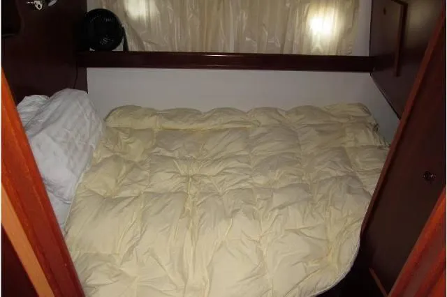 Slide: The Image of Cozy cabin bed in 2006 Beneteau Swift Trawler 42 with soft bedding and wooden accents. - 44