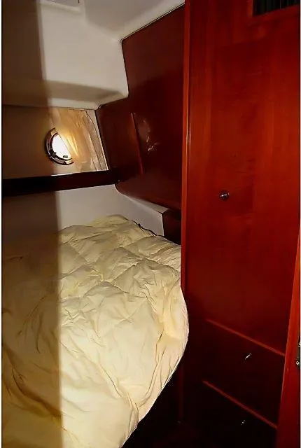 Slide: The Image of 2006 Beneteau Swift Trawler 42 cabin with wooden interior and cozy bed. - 45