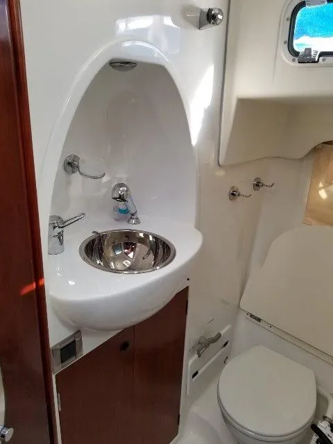 Slide: The Image of 2006 Beneteau Swift Trawler 42 bathroom with sink, toilet, and porthole window. - 47