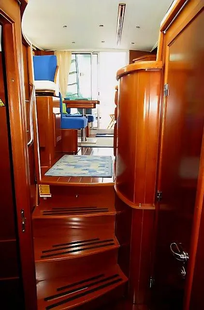 Slide: The Image of Interior view of 2006 Beneteau Swift Trawler 42, featuring wooden stairs and seating area. - 49