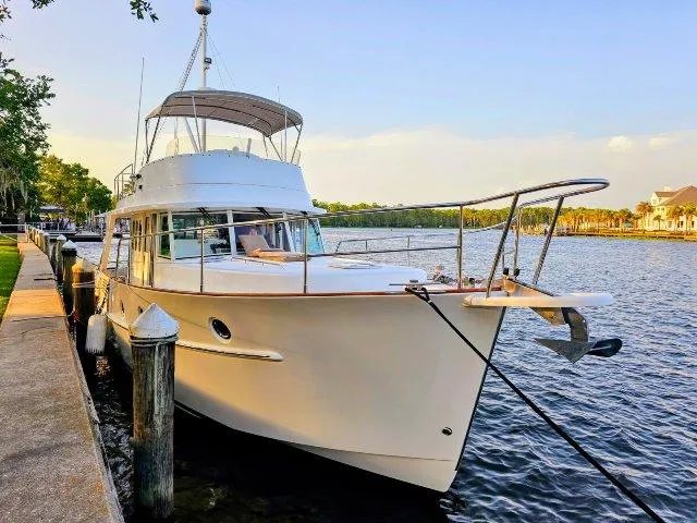 Slide: The Image of 2006 Beneteau Swift Trawler 42 docked by a serene waterfront. - 5