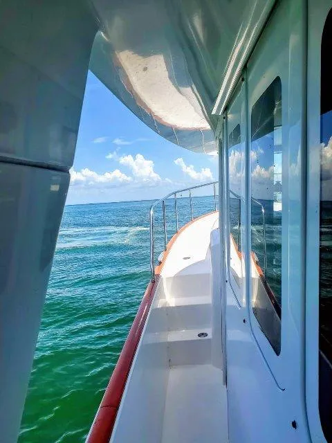 Slide: The Image of 2006 Beneteau Swift Trawler 42 cruising on open sea under clear blue skies. - 9