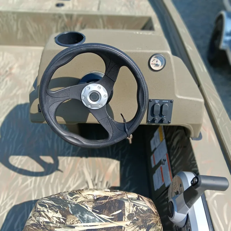 Slide: The Image of 2025 Tracker Grizzly 1754 SC boat steering console with camo seat and controls. - 10