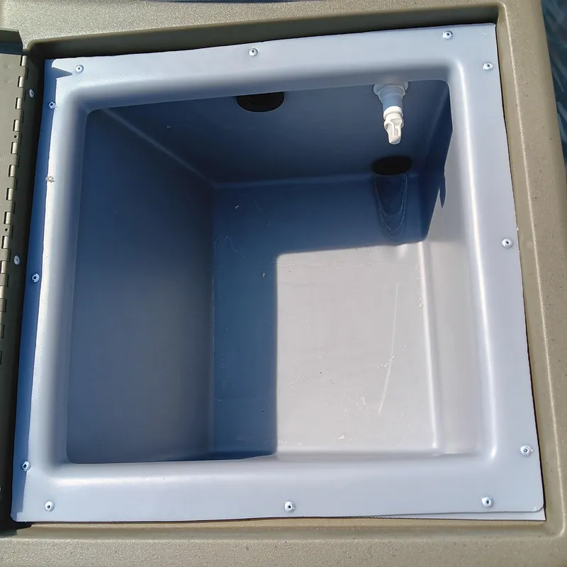 Slide: The Image of Livewell compartment in 2025 Tracker Grizzly 1754 SC boat, featuring a drain and faucet. - 8