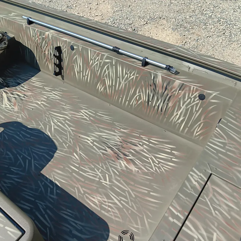 Slide: The Image of 2025 Tracker Grizzly 1754 SC boat interior with camouflage pattern and rod holder. - 9