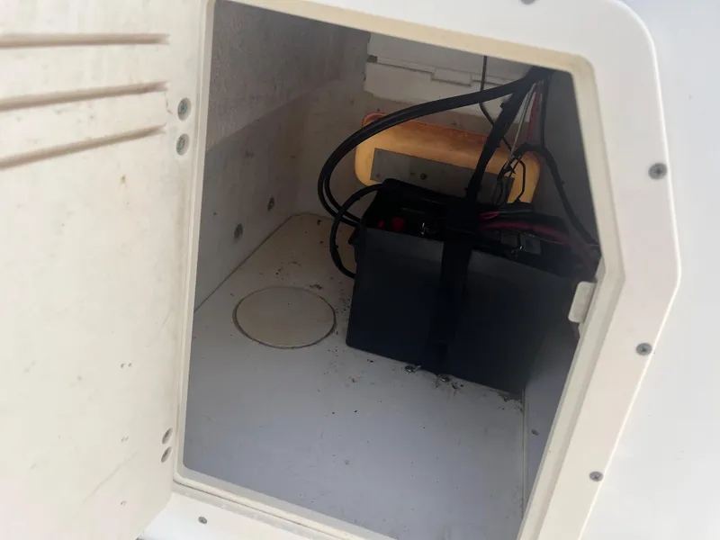 Slide: The Image of Battery compartment of a 2008 Boston Whaler 170 Montauk boat, showing wiring and storage space. - 11