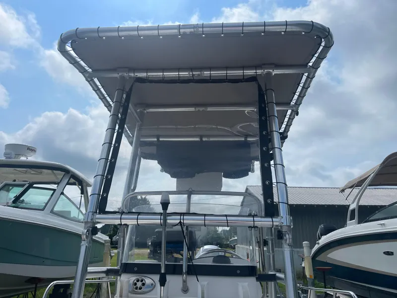 Slide: The Image of 2008 Boston Whaler 170 Montauk boat with T-top, docked under cloudy sky. - 15
