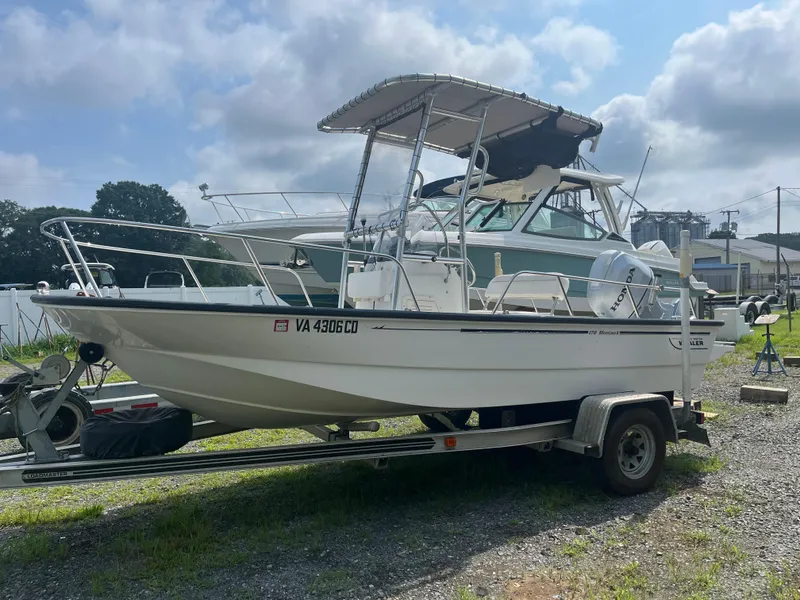 Slide: The Image of 2008 Boston Whaler 170 Montauk boat on trailer, parked outdoors under cloudy sky. - 18