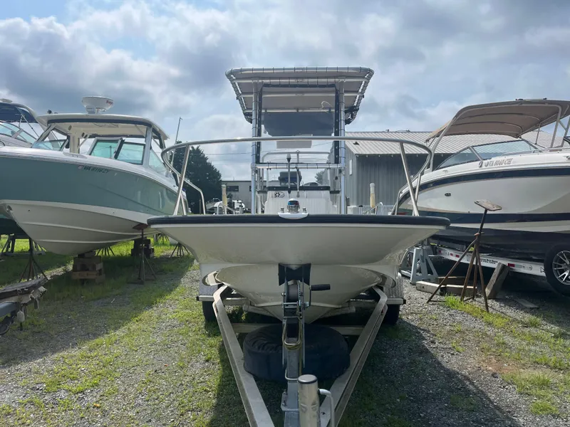 Slide: The Image of 2008 Boston Whaler 170 Montauk boat on trailer, surrounded by other boats, under cloudy sky. - 19