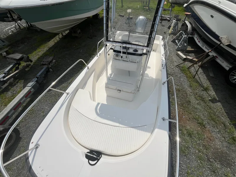 Slide: The Image of 2008 Boston Whaler 170 Montauk boat, white interior, parked outdoors among other boats. - 2