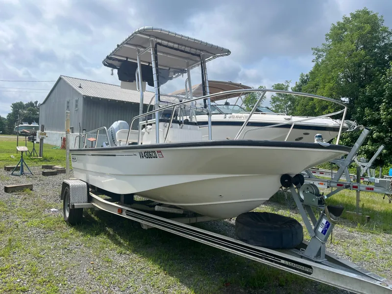 Slide: The Image of 2008 Boston Whaler 170 Montauk boat on trailer, parked outdoors near a metal building. - 20