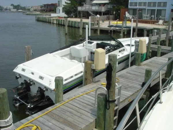 Slide: The Image of 1998 Corsa offshore flat deck boat docked at a marina. - 2