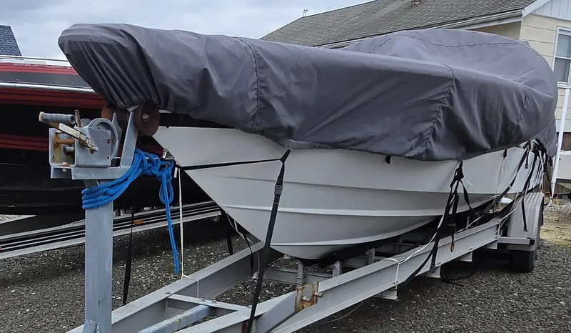 Slide: The Image of 1998 Corsa offshore flat deck boat covered on a trailer, ready for transport. - 6