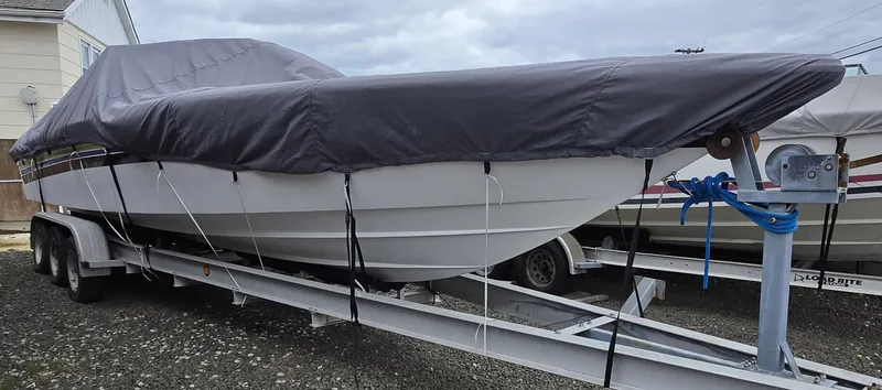 Slide: The Image of 1998 Corsa offshore flat deck boat covered on trailer, parked outdoors. - 7