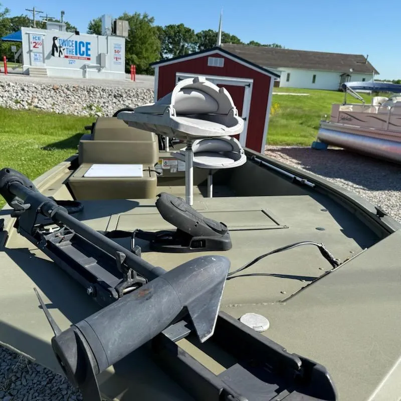 Slide: The Image of 2019 Tracker Grizzly Tracker 1648 MVX boat with seating and equipment, outdoors near a red shed. - 8