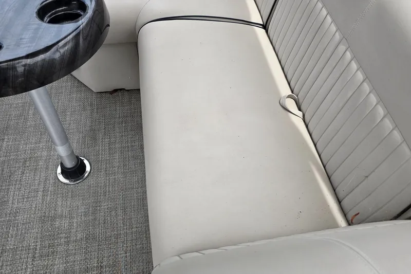 Slide: The Image of 2019 Qwest LS 818 RLS boat interior with beige seating and a small table. - 7