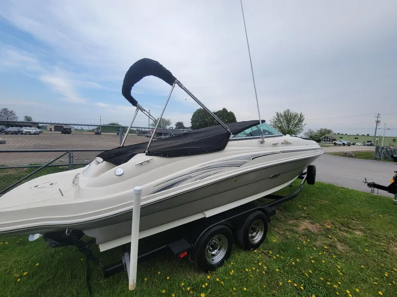 Slide: The Image of 2006 Sea Ray 220 Sundeck boat on trailer, parked on grass. - 10
