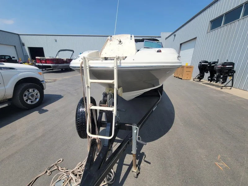 Slide: The Image of 2006 Sea Ray 220 Sundeck boat on trailer in industrial area. - 12