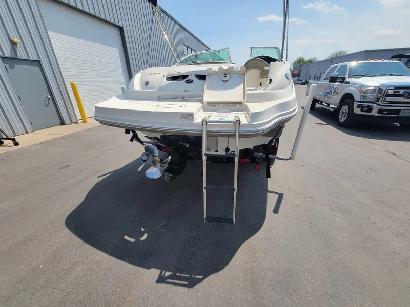 Slide: The Image of 2006 Sea Ray 220 Sundeck boat parked near a garage, rear view. - 13