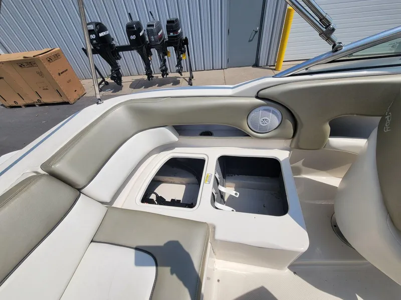 Slide: The Image of 2006 Sea Ray 220 Sundeck interior with open storage compartments and speaker. - 17