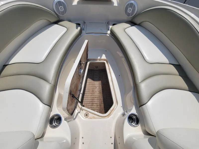 Slide: The Image of 2006 Sea Ray 220 Sundeck interior with open storage compartment and cushioned seating. - 25