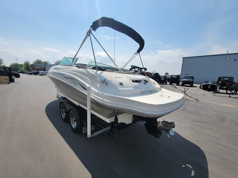 Slide: The Image of 2006 Sea Ray 220 Sundeck boat on trailer, parked outdoors under clear sky. - 3